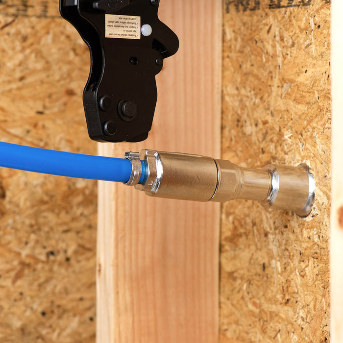 A PEX crimp tool crimping the ring fittings to connect the PEX line to the half inch PEX crimp inlet.