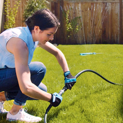 A woman connects the hose adapter to turn on a sprinkler.|42444323586298