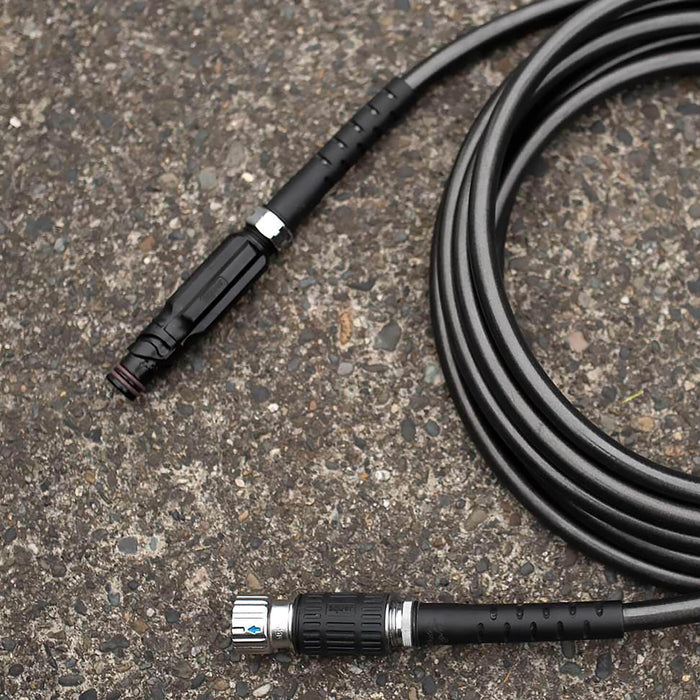 A black hose adapter sits disconnected on concrete.|42444323586298