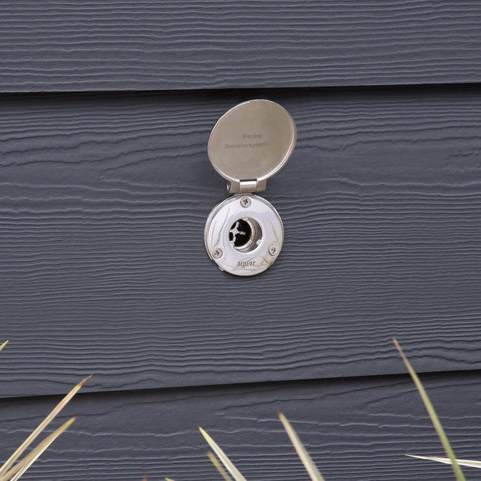 The brushed stainless house hydrant v1+ with the cover open on dark gray lap siding.