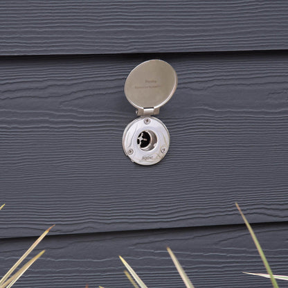 The brushed stainless house hydrant v1+ with the cover open on dark gray lap siding.