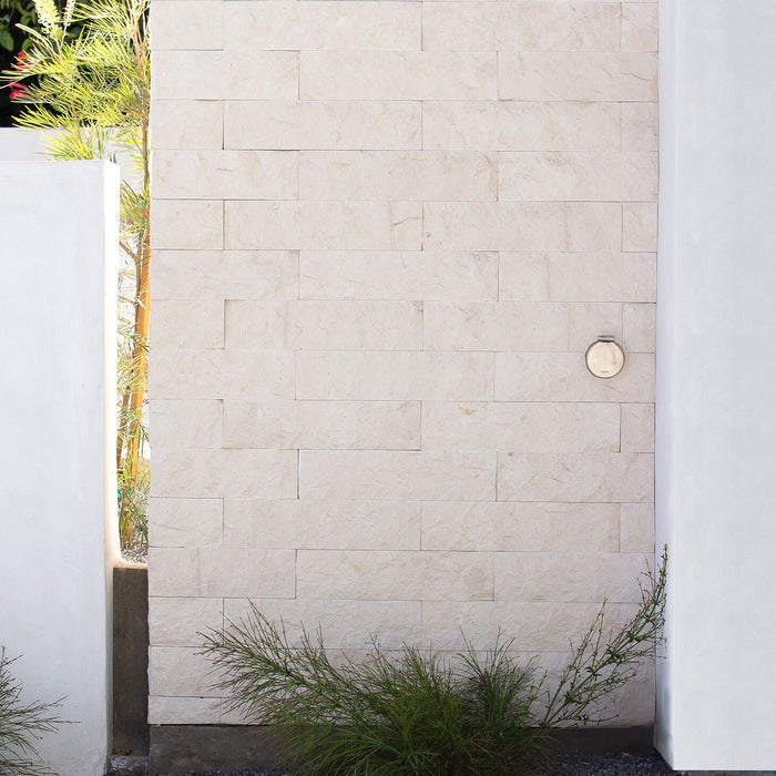 A brushed stainless v1+ debris cover shown on masonry siding.|47730978685178