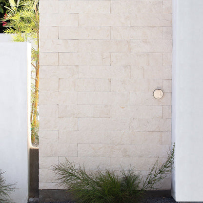 A brushed stainless v1+ debris cover shown on masonry siding.|47730978685178