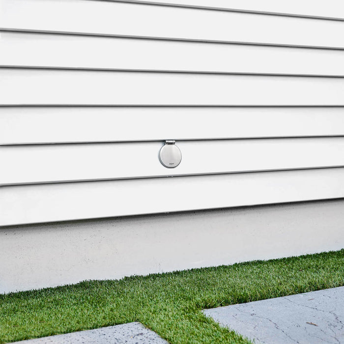 A brushed stainless  v1+ debris cover shown on white lap siding.|47730978685178
