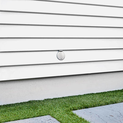 A brushed stainless  v1+ debris cover shown on white lap siding.|47730978685178