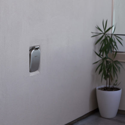 A brushed stainless v2+ debris cover shown on stucco.|47730985795834