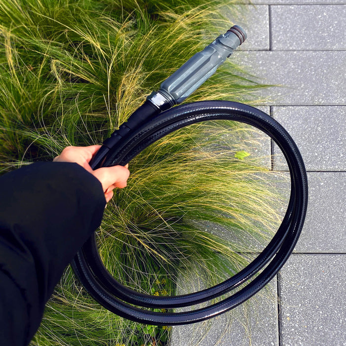 Hand holding a slate gray straight hose connector and hose.|42443927617786